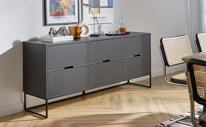 Sideboard in Dunkelgrau mit Dekoartikeln und Wandbildern